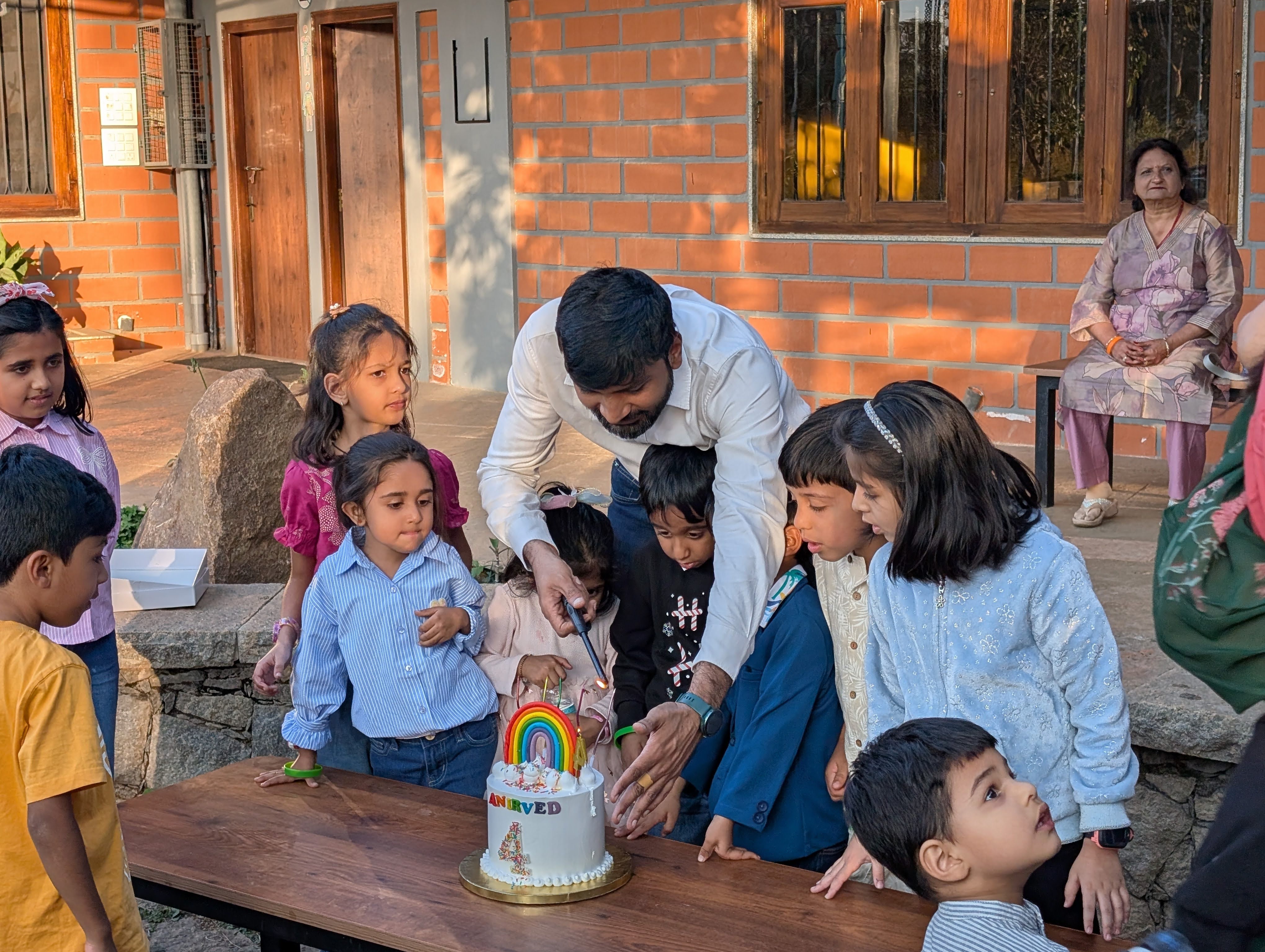Children gathered around the birthday cake