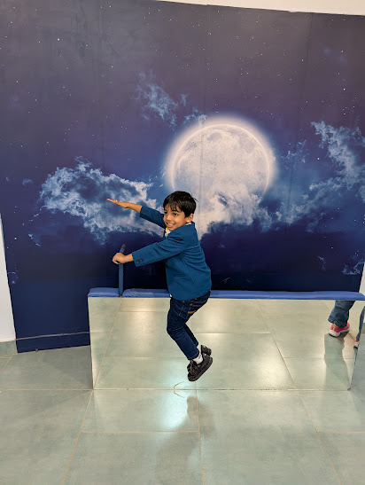 Child posing at the moon mirror illusion